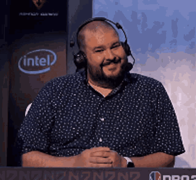 a man wearing headphones is sitting in front of a sign that says intel
