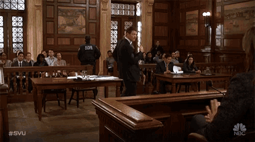 a man in a suit stands in front of a crowd in a courtroom with the hashtag #svu on the bottom