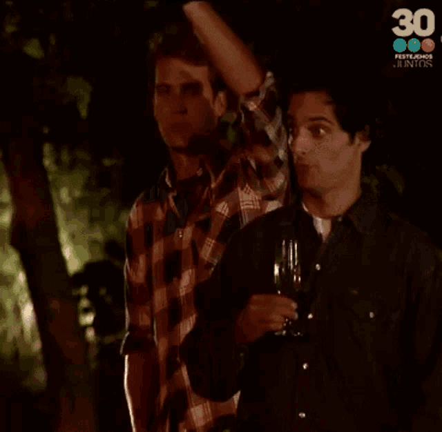 a group of men are toasting with a glass of beer in front of a screen that says 30
