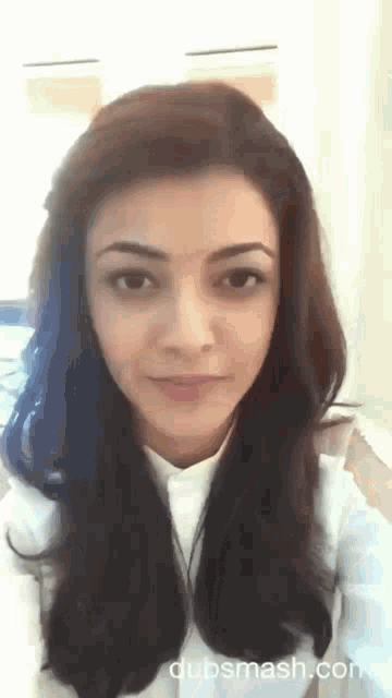 a close up of a woman 's face with a white shirt on