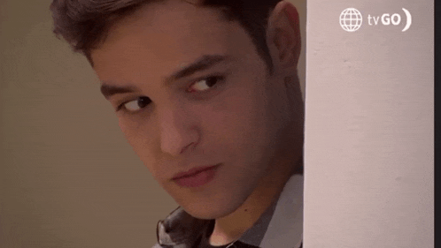 a close up of a young man 's face with a tv go logo behind him