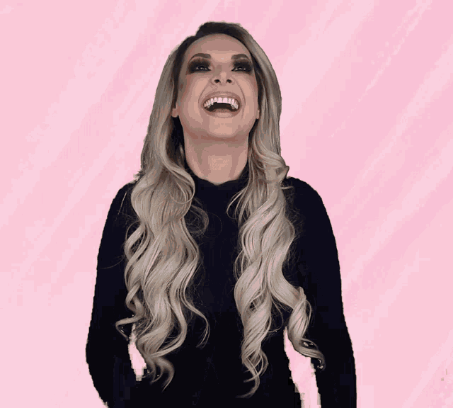 a woman with long blonde hair is laughing with her mouth wide open