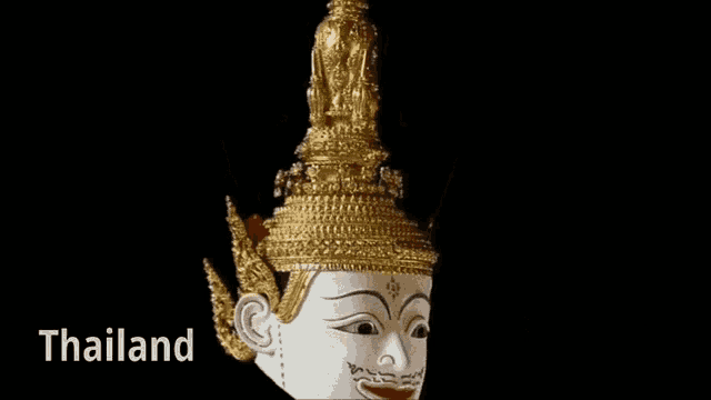 a statue of a man with a gold crown and the word thailand below it