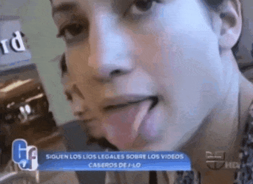 a woman is sticking her tongue out in front of a banner that says " siguen los lios legales sobre los videos "