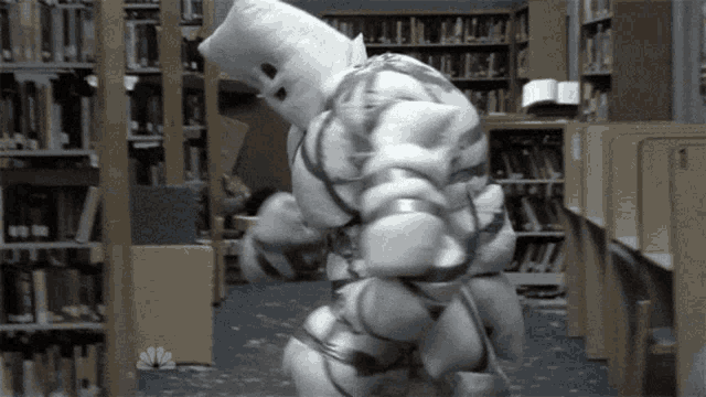 a cartoon character is standing in a library with a nbc logo in the corner