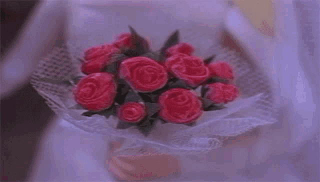 a woman in a white dress is holding a bouquet of pink flowers