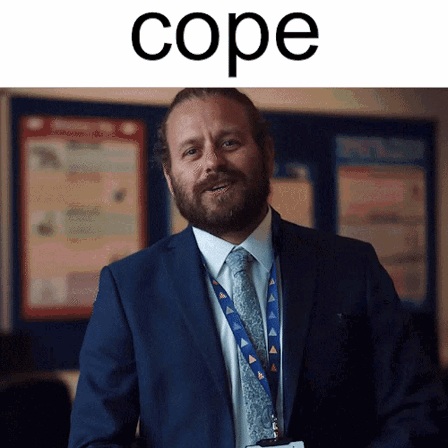 a man in a suit and tie stands in front of a poster that says cope