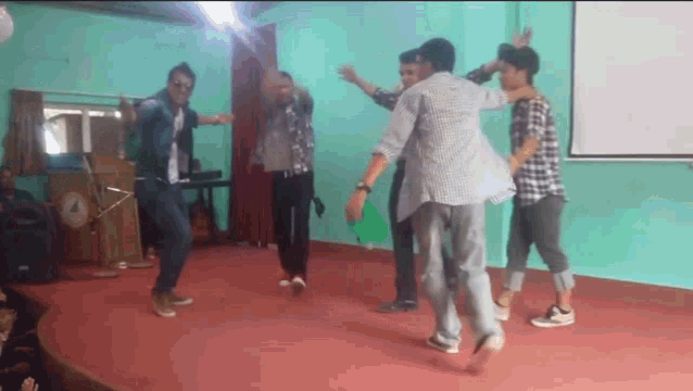 a group of young men are dancing in a room