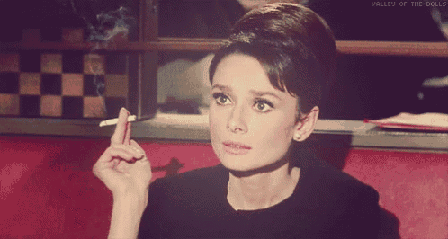 a woman smoking a cigarette with valley-of-the-dolls on the bottom