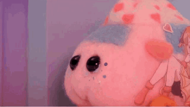 a close up of a stuffed animal with a person sitting on it 's back .