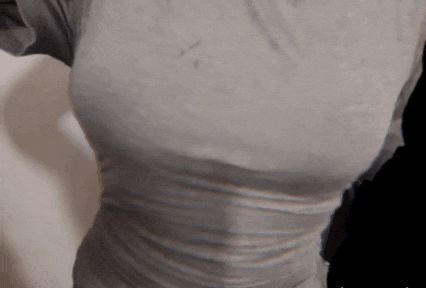 a woman 's breasts are shown in a close up of a gray shirt .