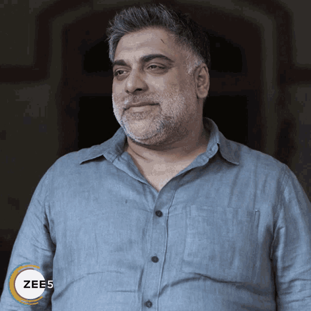 a man wearing a blue shirt with the word zees on the bottom