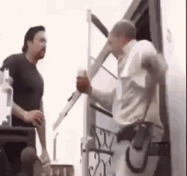 two men are standing next to each other in front of a trailer .
