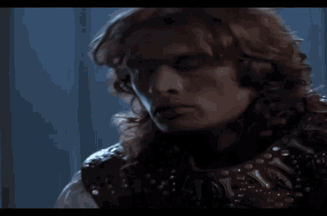 a man with long hair is wearing a leather jacket with studs
