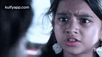 a young girl is making a funny face in a blurry photo .