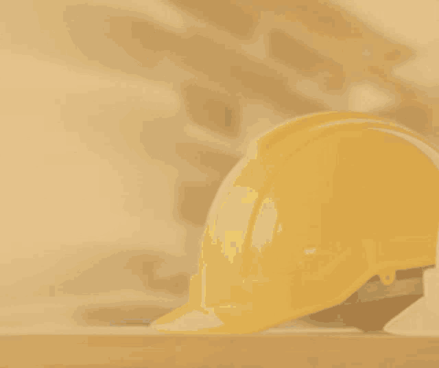 a hand holding a hard hat with a hammer and a city in the background