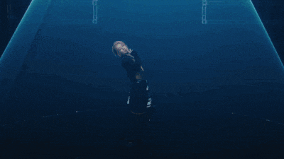 a person is standing in a dark room with a blue light shining on them