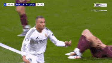a soccer player wearing a white emirates jersey celebrates a goal