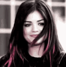 a close up of a woman 's face with long black hair and red highlights .
