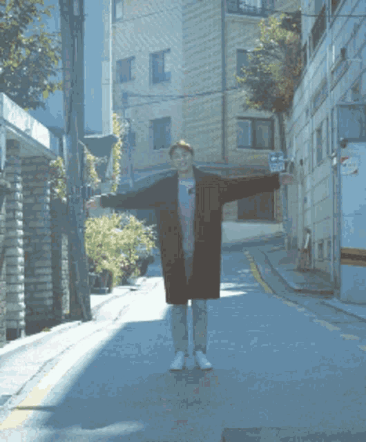 a man with his arms outstretched is wearing a pink shirt that says ' n.o. ' on it