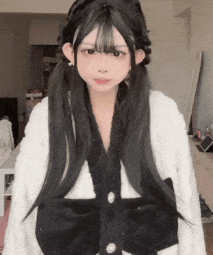 a girl with pigtails is wearing a white sweater with a black bow