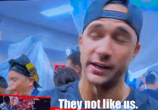 a man wearing a baseball cap says " they not like us "