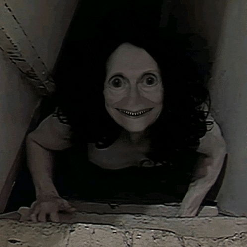 a woman with a mask on her face is crawling out of a hole in the wall