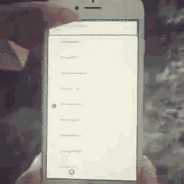 a person is holding a cell phone in their hand and pressing a button on the screen .