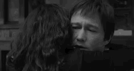 a man is hugging a woman in a black and white photo with the words `` a bientot '' written in white letters .