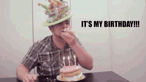 a man wearing a birthday hat is eating a cupcake with candles on it .