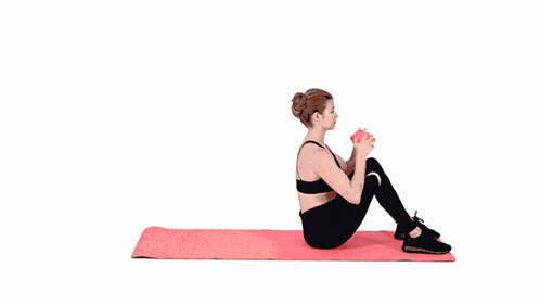 a woman is laying on a pink mat doing exercises .