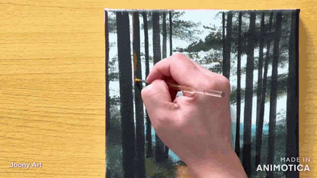 a hand is holding a brush on a canvas with the words made in animatica on the bottom