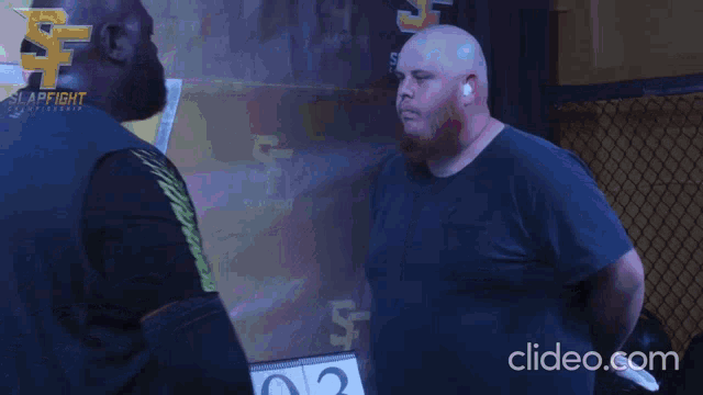 a man giving another man a high five in front of a sign that says slap fight