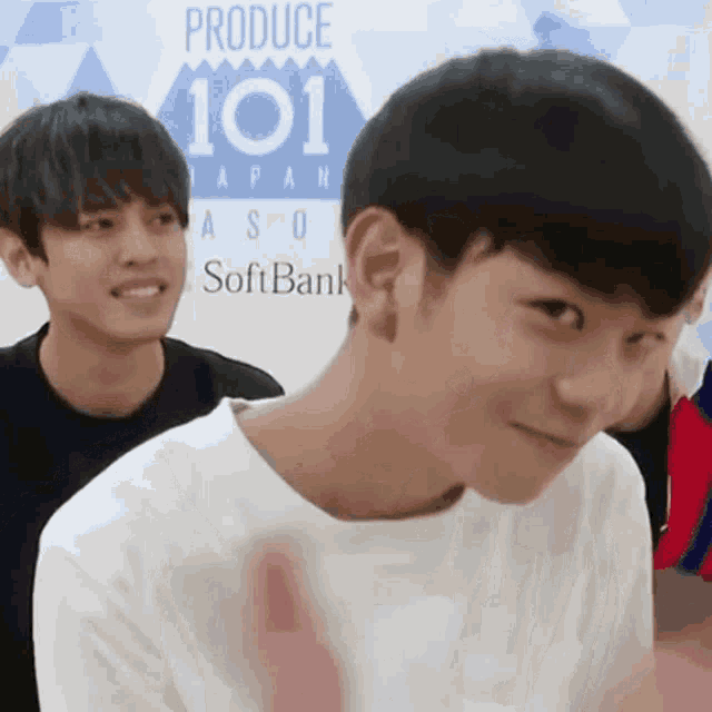 two young men are standing in front of a banner that says produce 101 japan