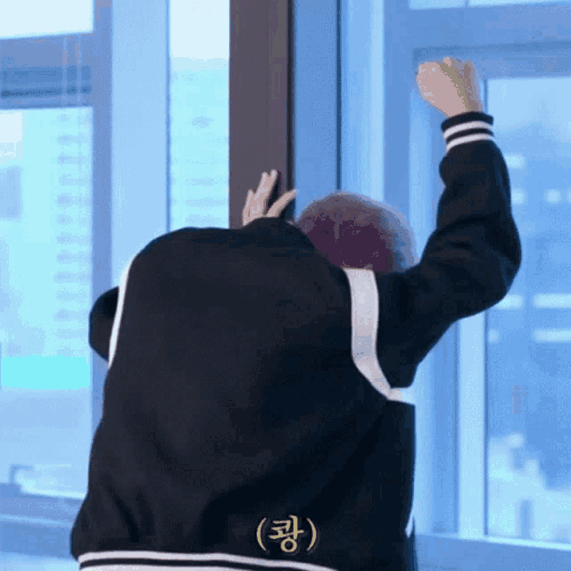 a man in a black jacket with korean writing on the back