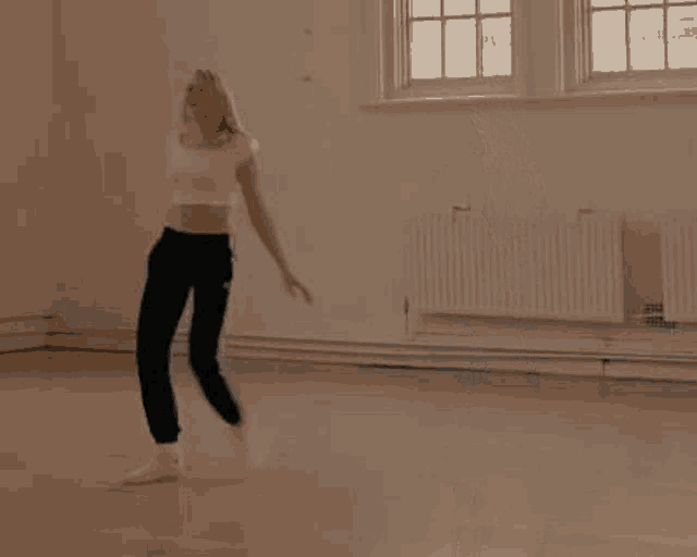 a woman is dancing in a room in a dance studio .