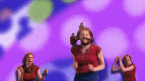 a woman in a red shirt is dancing on a purple background
