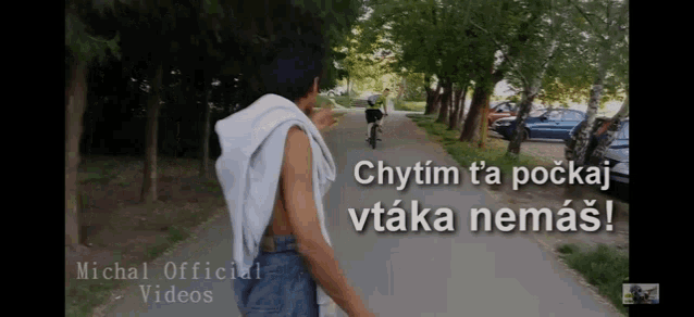 a man walking down a street with the words michal official videos on the bottom right