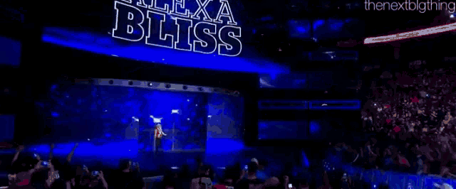 a woman is standing on a stage with the word bliss on the screen