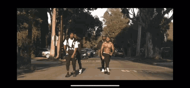 a group of men are walking down a street with a sign that says ' st ' on it