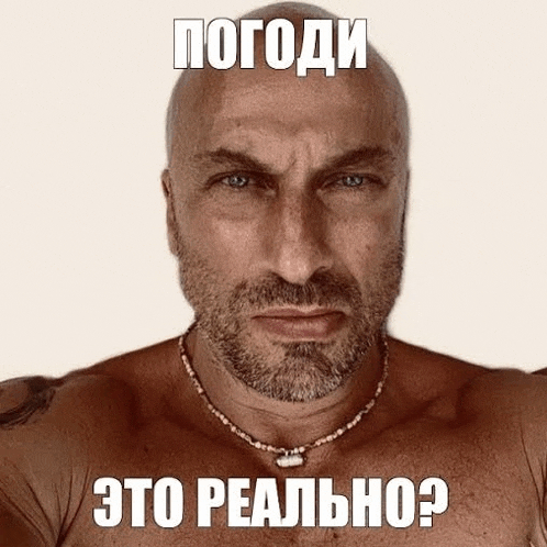 a shirtless man with a beard is wearing a necklace and has the words " это реально " written on his face