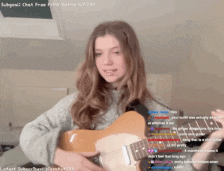 a girl is playing a guitar in front of a screen that says ' subgoals chat free print raffle '