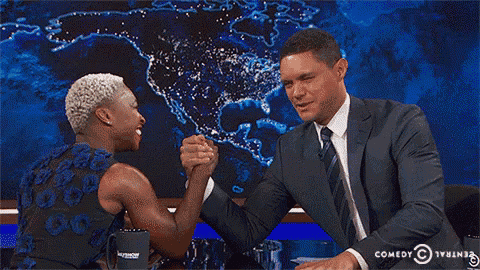 a woman is smiling while holding a man 's hand and laughing .