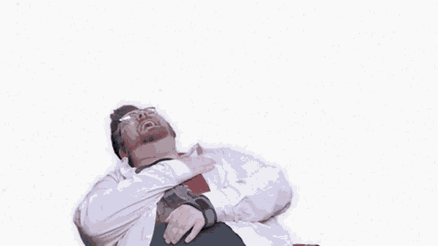 a man in a white shirt and tie is laying down with his hand on his chest in front of a wall that says fans of movie