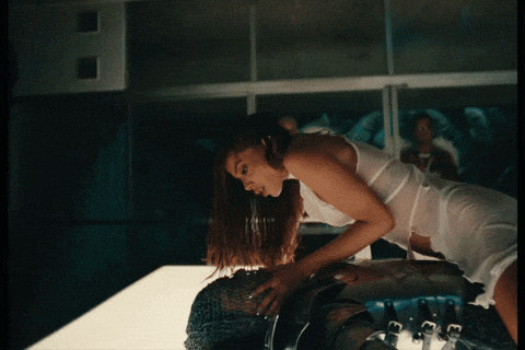 a woman in a white top is laying on a man 's back