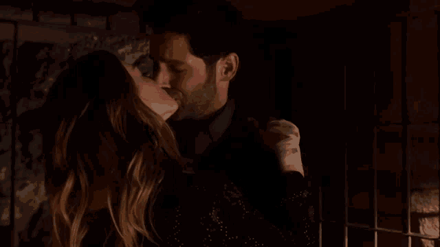 a man and a woman are kissing in the dark