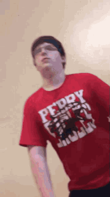 a man is wearing a red shirt that says peddy