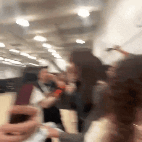 a blurry picture of a group of people dancing in a room