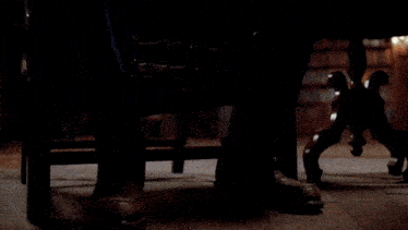a man covering his face with his hands while sitting in a dark room