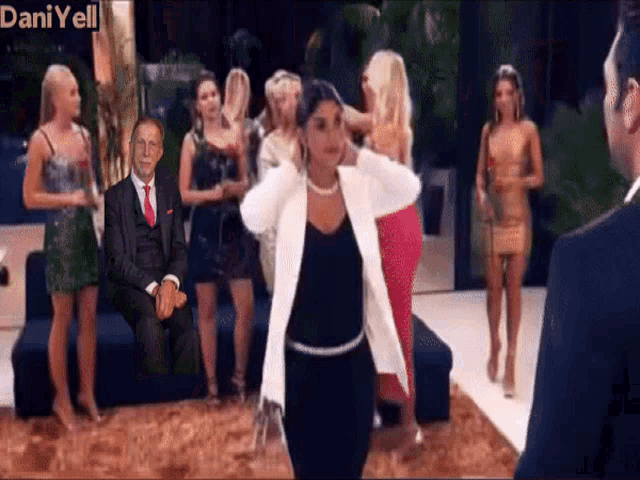 a man in a suit and tie is sitting on a couch surrounded by women with dani yell written in the corner
